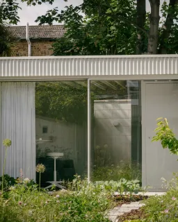Ngôi nhà màu trắng với cửa kính thông suốt ẩn nấp trong khu vườn hoa dại
