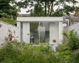 Ngôi nhà màu trắng với cửa kính thông suốt ẩn nấp trong khu vườn hoa dại
